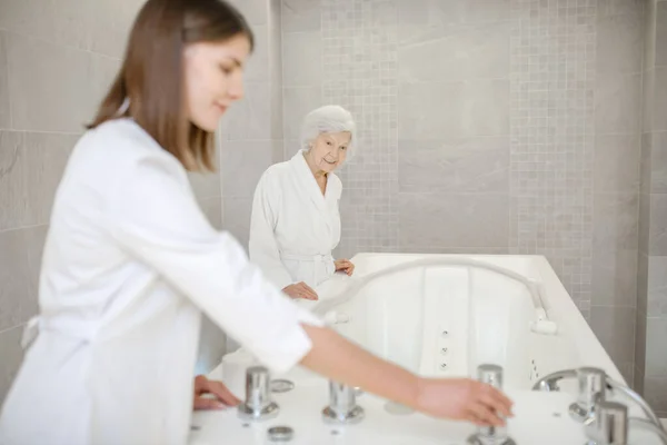 Spezialist im Wellness-Salon bereitet das Bad für die Hydromassage vor — Stockfoto