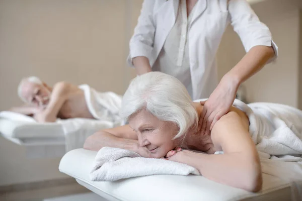 Massagetherapeutin bei einer Rückenmassage für eine ältere Kundin — Stockfoto