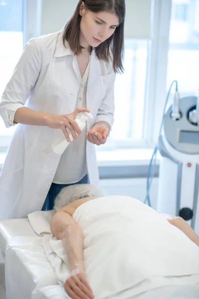 Female massage therapist doing back massage procedures to a woman — Stock Photo, Image