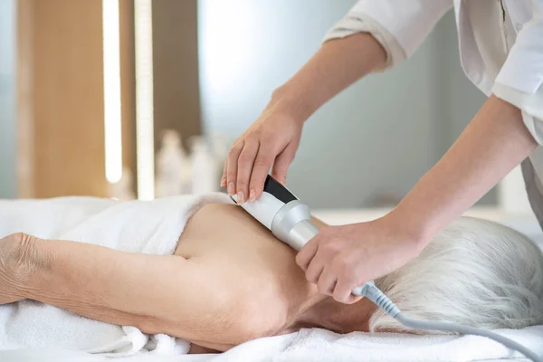 Massage therapeut doet terug massage procedures om een grijs-harige vrouw — Stockfoto