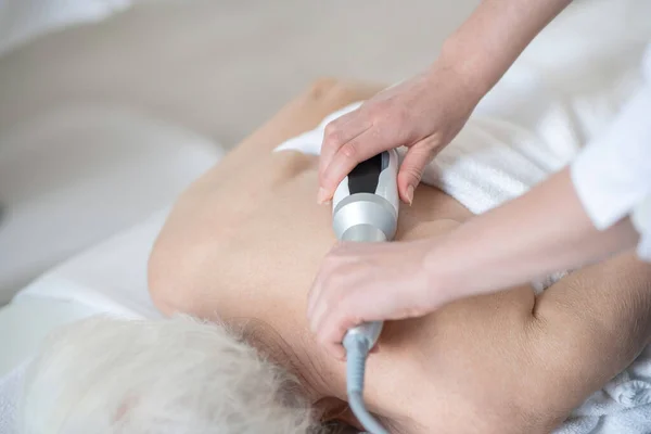 Massage therapeut doet terug massage procedures om een grijs-harige vrouw — Stockfoto