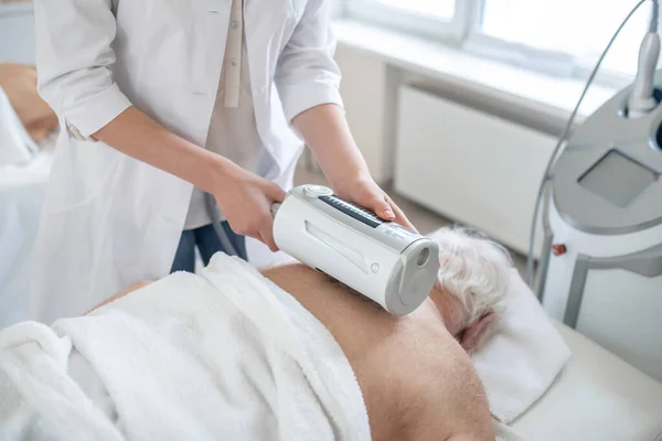 Fisioterapeuta que realiza procedimientos antiestenocondrosis a una paciente femenina — Foto de Stock