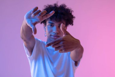 Koyu tenli adam hayali kamerayla resim yapıyor.