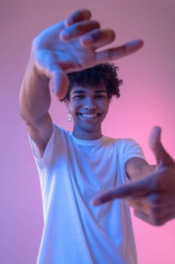 Koyu tenli adam hayali kamerayla resim yapıyor.