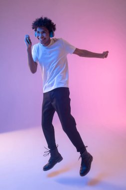 İnternette ses günlüğü dinleyen esmer tenli bir adam.