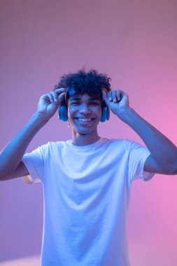 Koyu tenli kulaklıklı adam gülümsüyor ve mutlu görünüyor.