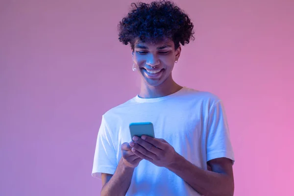 Chico afroamericano leyendo un mensaje en un smartphone — Foto de Stock