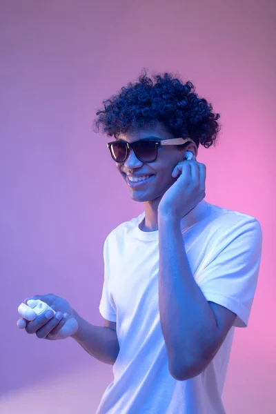Young mulatto guy in headphones and in sunglasses looking stylish — Stock Photo, Image