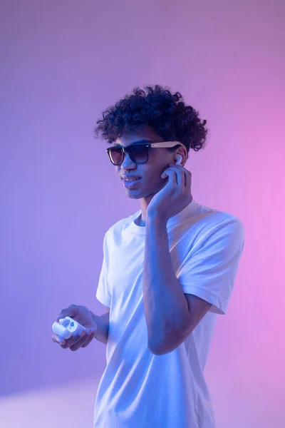 Young mulatto guy in headphones and in sunglasses looking stylish — Stock Photo, Image