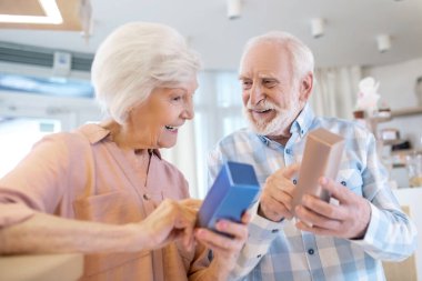 Gri saçlı çift parfüm seçiyor ve heyecanlı görünüyorlar.