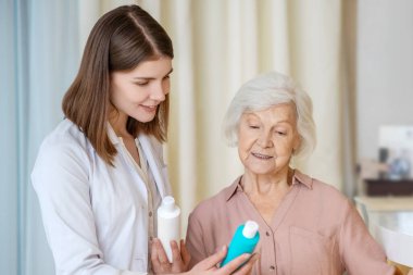 Koyu renk saçlı kozmetik uzmanı yeni güzellik ürünlerini bayan müşteriye gösteriyor.