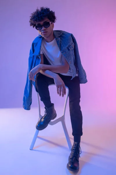 Modelo masculino americano africano elegante em casaco de ganga posando em estúdio e olhando lindo — Fotografia de Stock