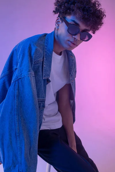 Stylish african american male model in denim jacket posing in studio and looking gorgeous — Stock Photo, Image