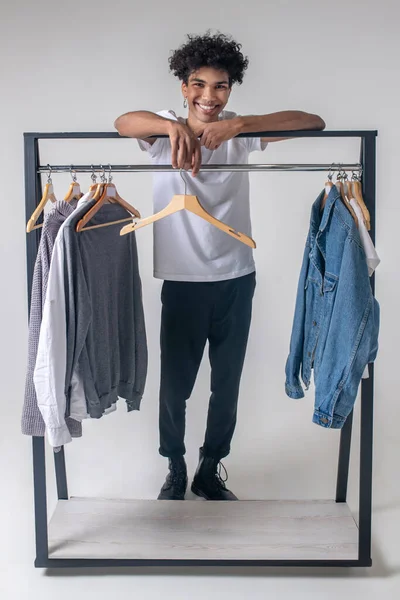 Afroamerikansk ung kille står nära hängare med kläder — Stockfoto