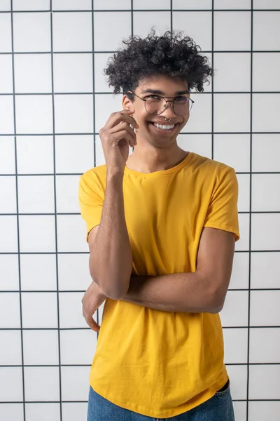 Afro americano joven chico en gafas sonriendo y buscando positivo — Foto de Stock