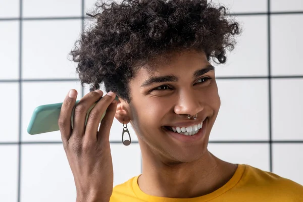 Afrikaans amerikaans jong guy met een smartphone luisteren naar een voice message — Stockfoto