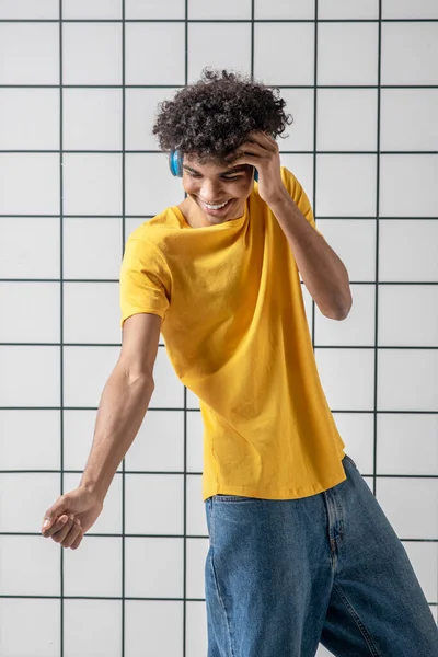 Afro americano joven chico en auriculares sonriendo y buscando satisfecho — Foto de Stock