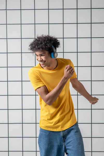 Afrykański amerykański młodzieniec w słuchawkach słuchający muzyki i tańczący — Zdjęcie stockowe