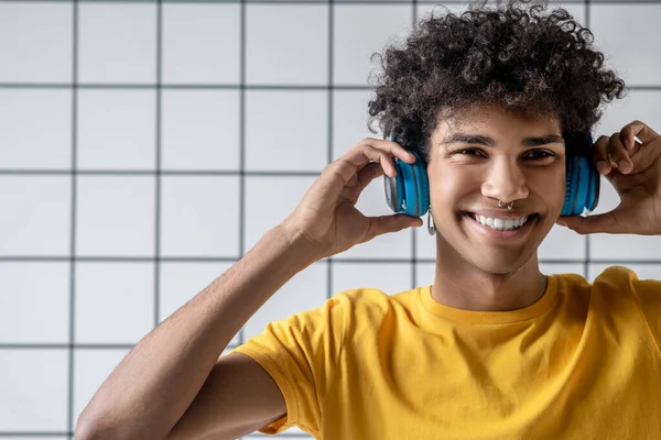 Afro americano joven chico en auriculares sonriendo y mirando feliz — Foto de Stock