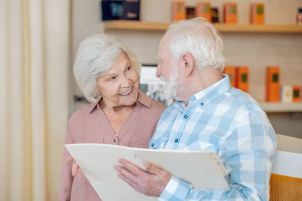 Pareja de cabello gris buscando trhough la lista de precios en el centro de spa y buscando emocionado — Foto de Stock