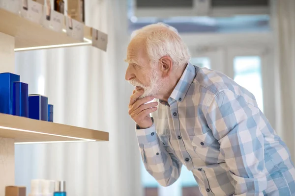 Mature man choosing a new fragrance in a beauty shop — Stock Photo, Image