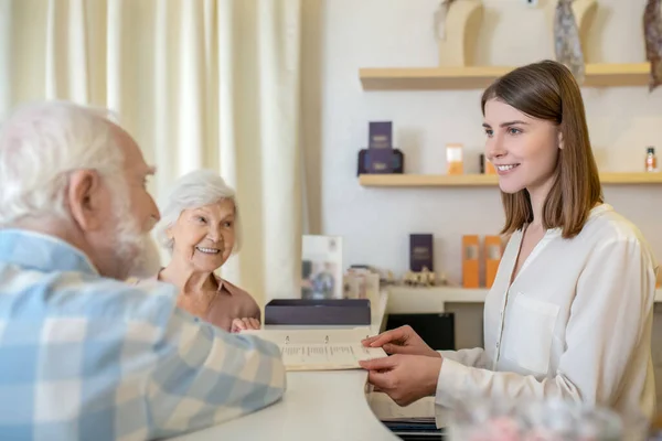 Elderly couple discussing procedures with a specialist in a spa center — Stock Photo, Image