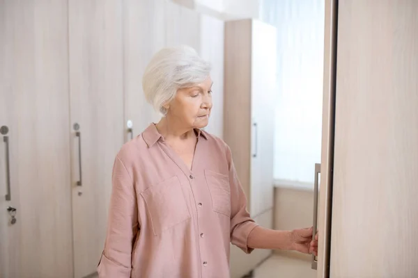 Gray-haired mature woman in a changing room in spa center — Stock Photo, Image