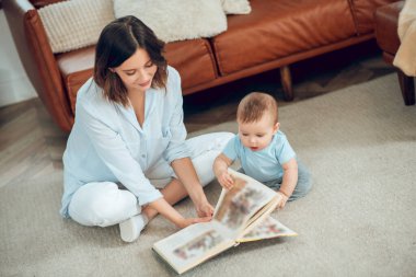 Interested mom and child looking at book