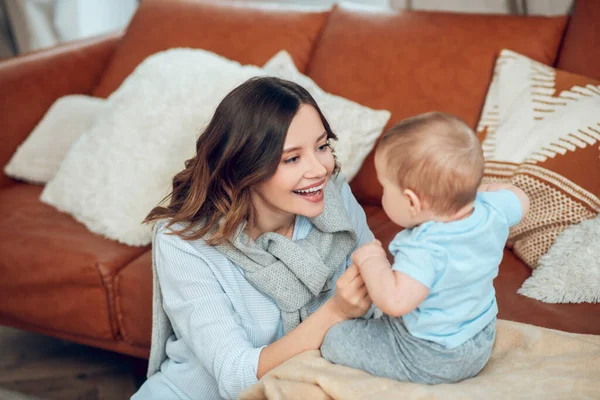 Mom attracting childs attention and playing with him — Stockfoto