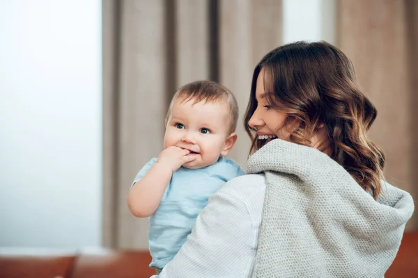 Happy woman with wavy hair holding baby — Fotografia de Stock