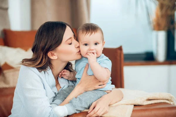 Woman with closed eyes kissing her baby — Fotografia de Stock