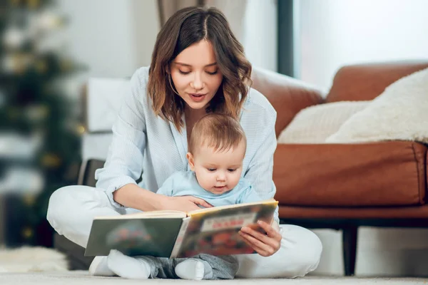 Focused mom reading book to small child — Fotografia de Stock