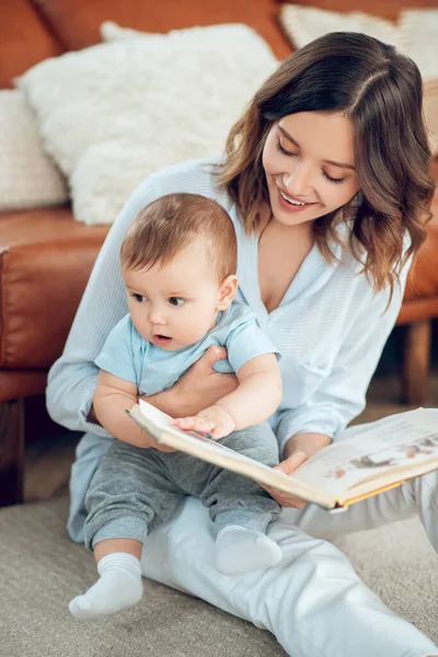 Mom reading book and little distracted child — Stockfoto