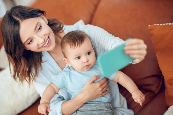 Cheerful woman with child taking selfie on smartphone — Foto de Stock