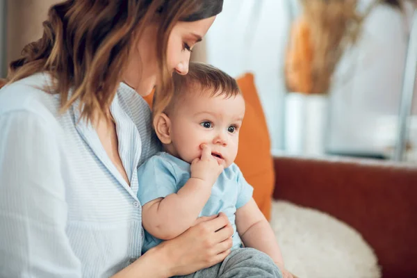 Loving mother holding child watching him — 图库照片