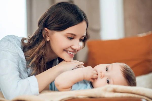 Happy mom looking at her child resting — ストック写真