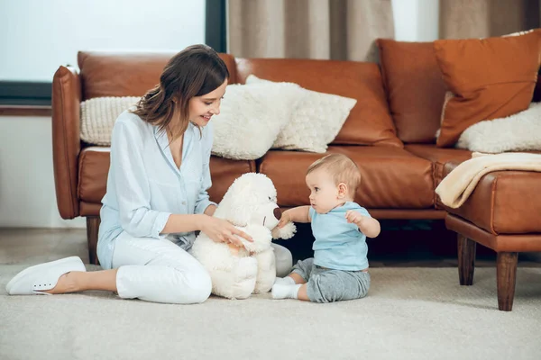 Mom showing teddy bear to interested child — Fotografia de Stock