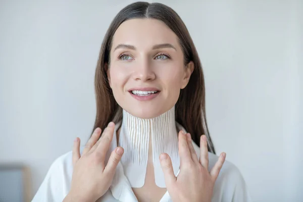 Pretty young woman visiting beauty center and having taping procedure — Stockfoto