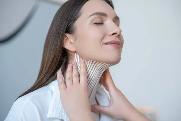 Aproape de o femeie tânără care vizitează centrul de frumusețe și care are o procedură de înregistrare pe mușchiul gâtului — Fotografie, imagine de stoc