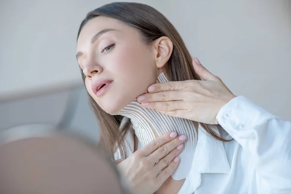 Linda joven mujer poniendo cinta en su cuello y buscando involucrado — Foto de Stock