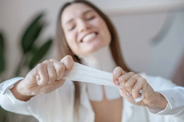 Linda joven mujer estirando la cinta antes de aplicarla — Foto de Stock