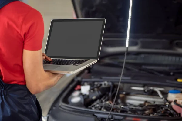 Open laptop in hands of car service worker — Stock Photo, Image