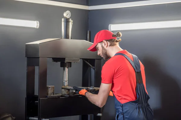 Man in workwear working near machine tool. — Stock Photo, Image