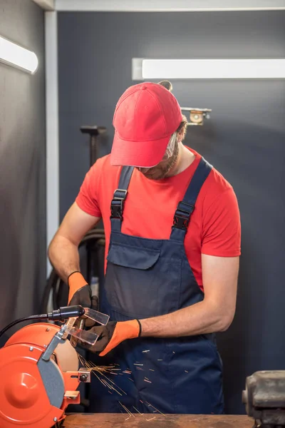 Hombre en gorra roja trabajando en la máquina — Foto de Stock