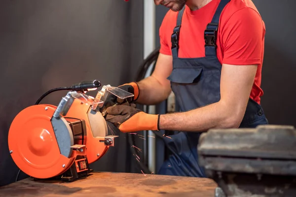 Male hands holding part near grinding machine — Stok fotoğraf