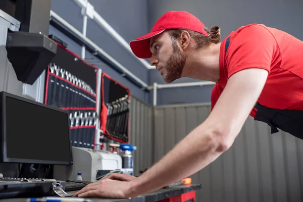 Trabajador de taller enfocado atento mirando la computadora — Foto de Stock