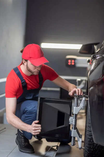 Mecánico automático que instala el soporte de alineación de rueda —  Fotos de Stock