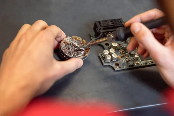 Male hands holding soldering iron near solder — Zdjęcie stockowe