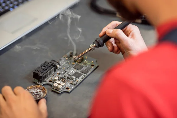 Manos del hombre con soldador y microcircuito — Foto de Stock