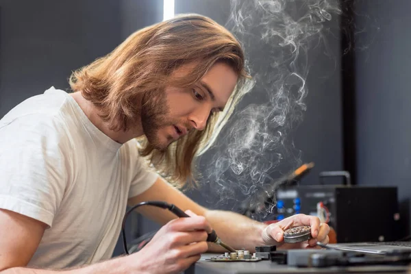 Man with soldering iron and box of solder — Zdjęcie stockowe